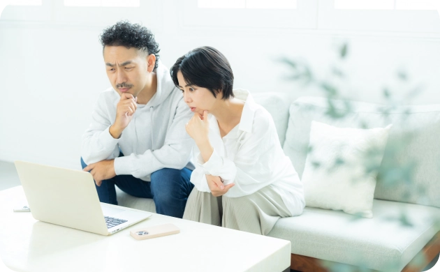 PCで住宅情報を真剣に検討するご夫婦